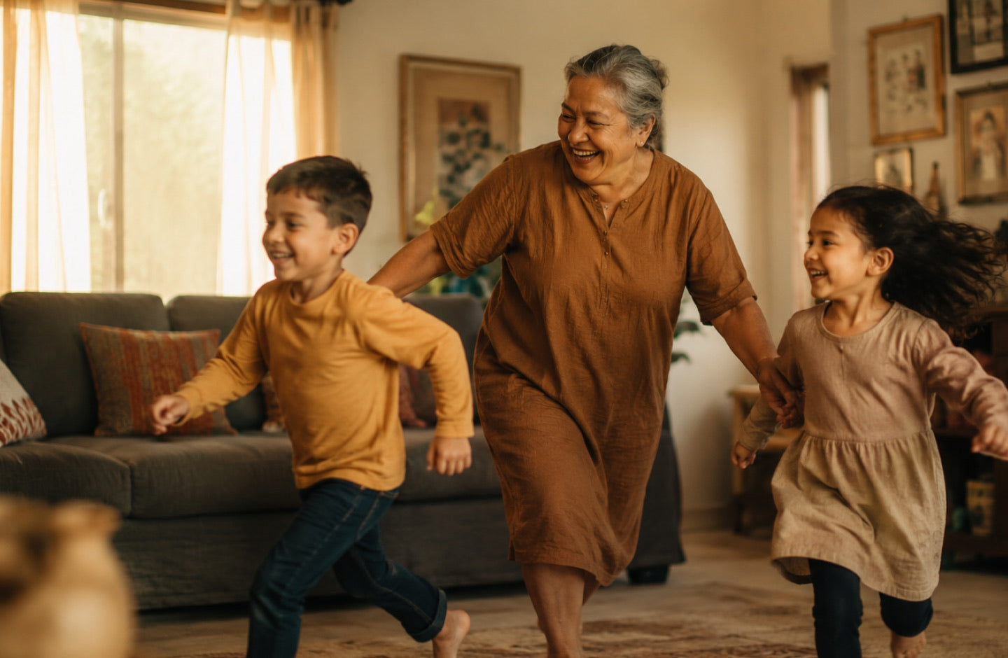 Grandmother laughing while running through the living room with her two grandchildren